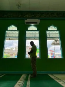 Muslim asian man praying performing salah at the mosque